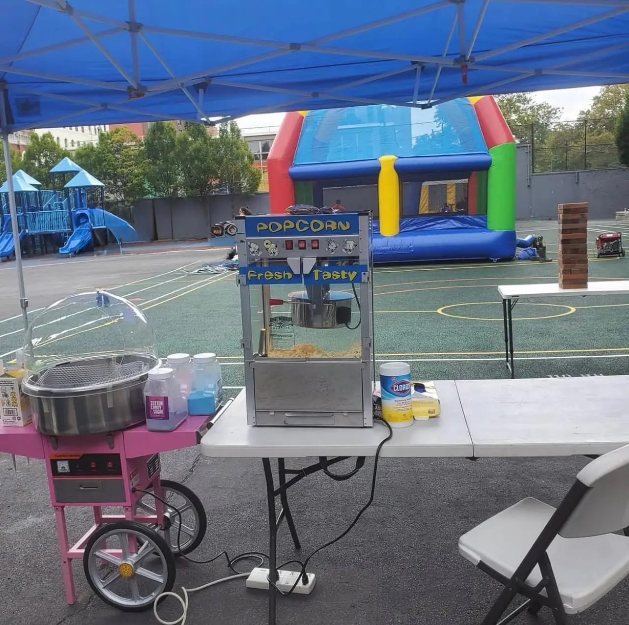 Popcorn and cotton candy machines set up under a party tent