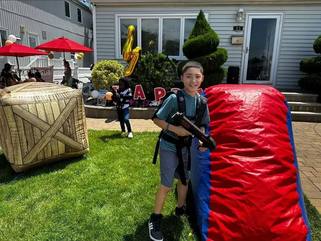 Boy taking cover behind an inflatable bunker during a laser tag party