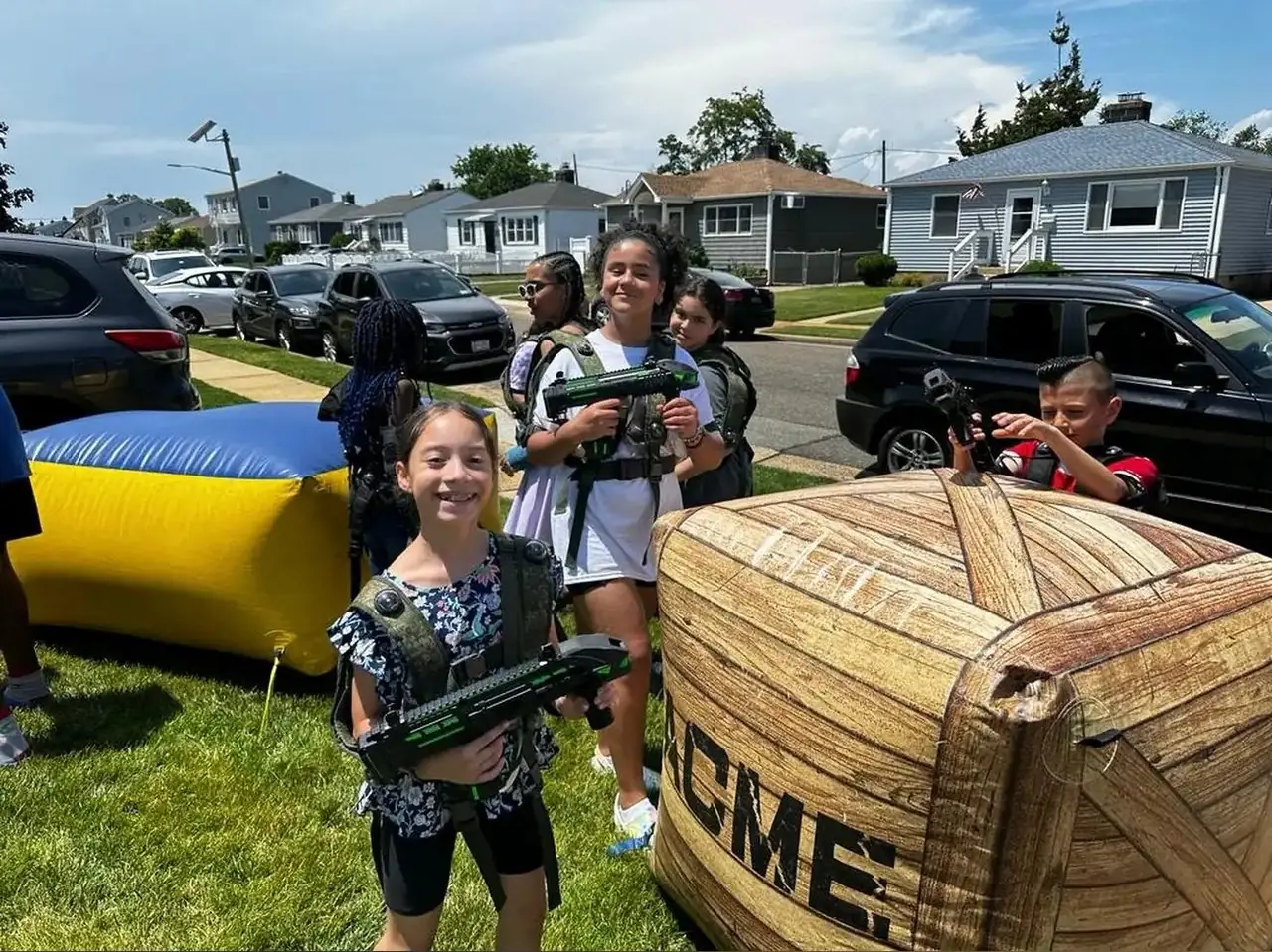 Kids playing arena-style laser tag behind inflatable crate obstacles