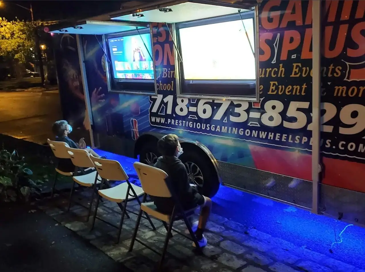Outdoor gaming screens lit up on the side of the game truck at night